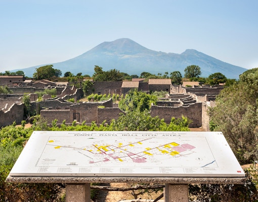 Pompeii Forum ruins with Mount Vesuvius in the background, map display in foreground.