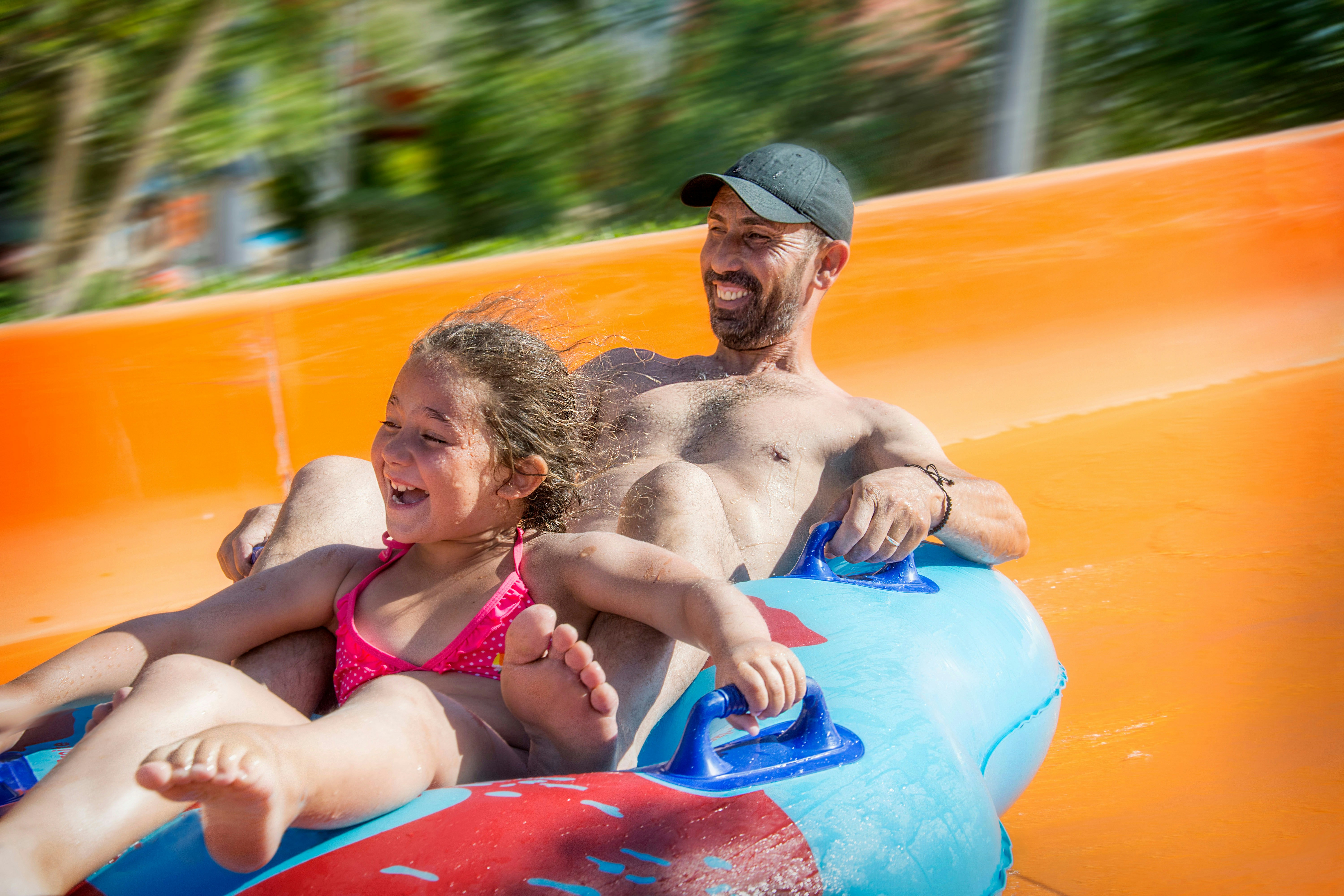 Father and daughter enjoying a ride on the Red Rush slide at Dubai LEGOLAND Water Park.