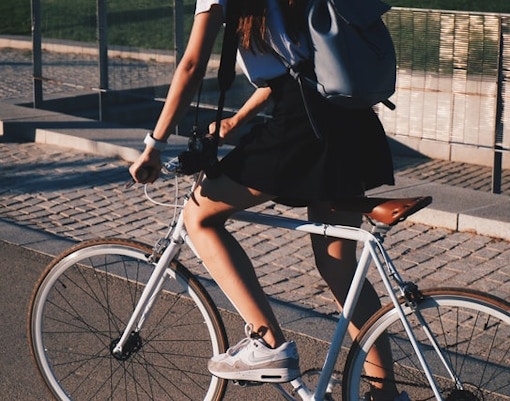 Cyclist riding on a city path with a backpack.