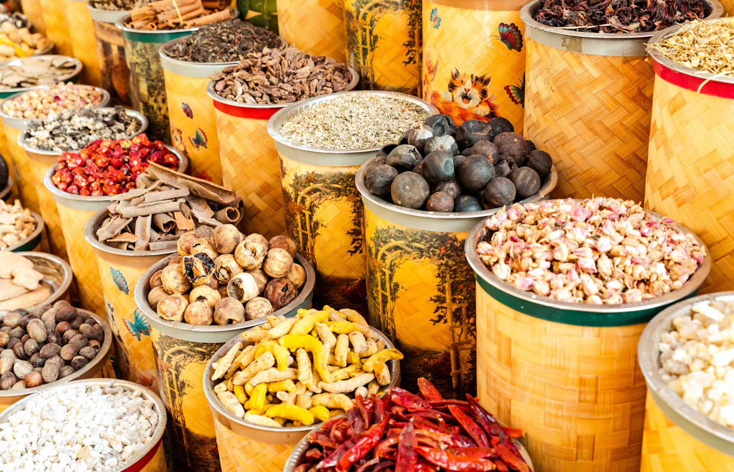 Spices in colorful baskets at Dubai Spice Souk, showcasing vibrant market atmosphere.
