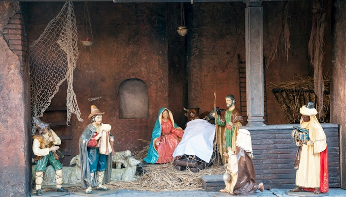 Nativity scene display in Rome during winter, featuring figures of Mary, Joseph, and the Magi.