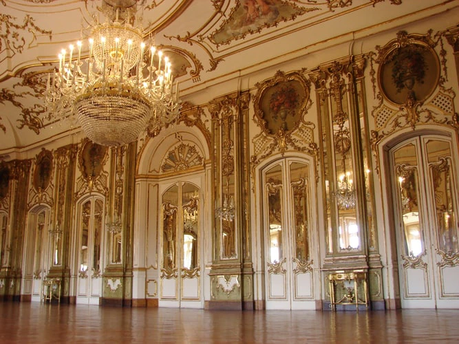 Royal Palace of Madrid ornate interior with chandeliers and gilded mirrors.