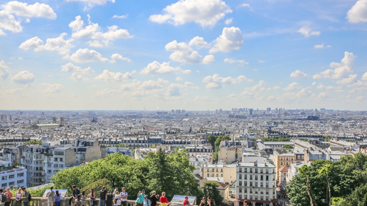 Eiffel Tower in Paris with tourists enjoying a sunny day, featured in Paris Travel Guide.