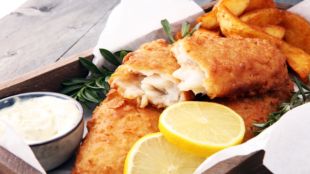 Fish and chips with lemon slices and tartar sauce, London street food.