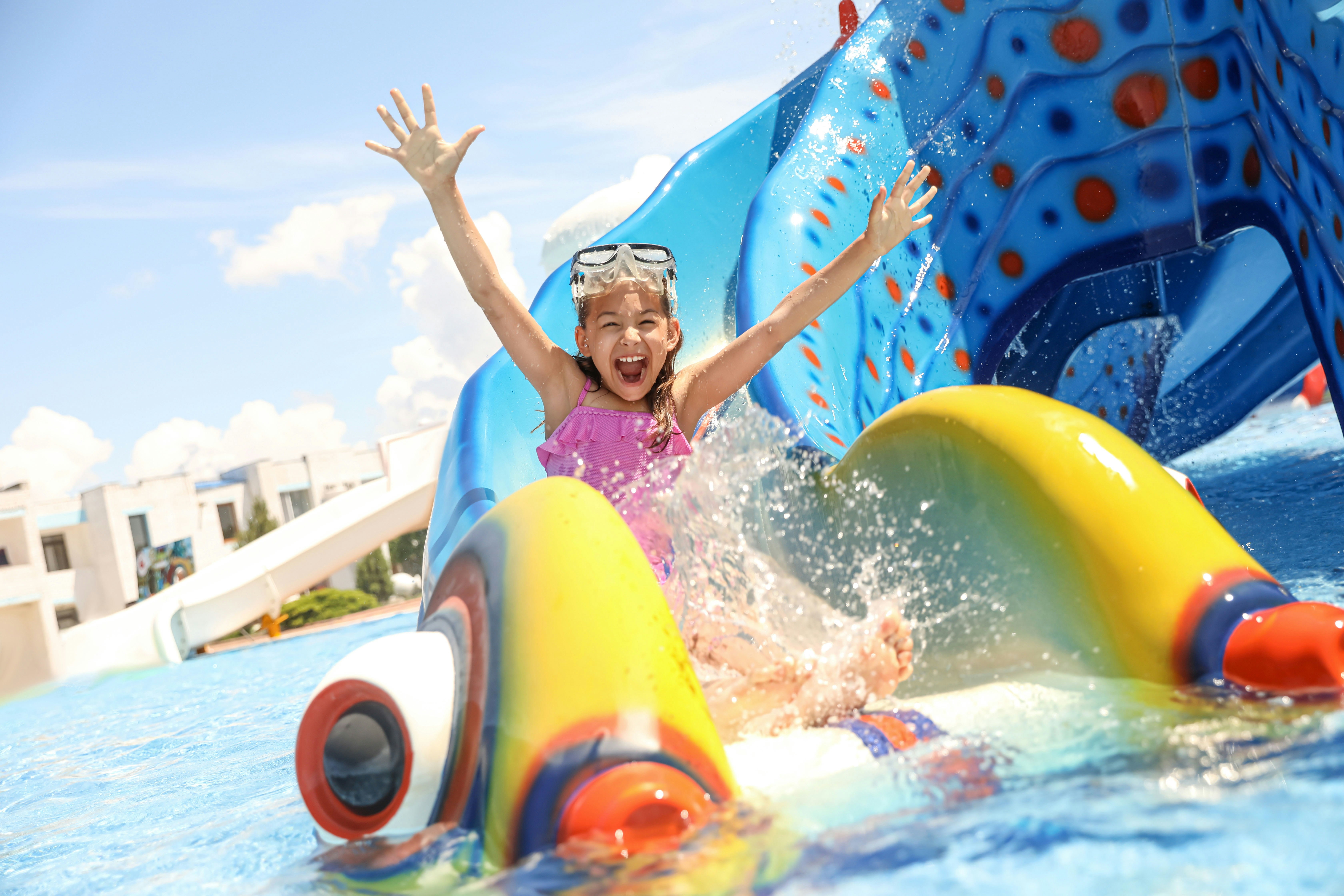 Child enjoying a colorful water slide at Barking Splash Park, Dubai.