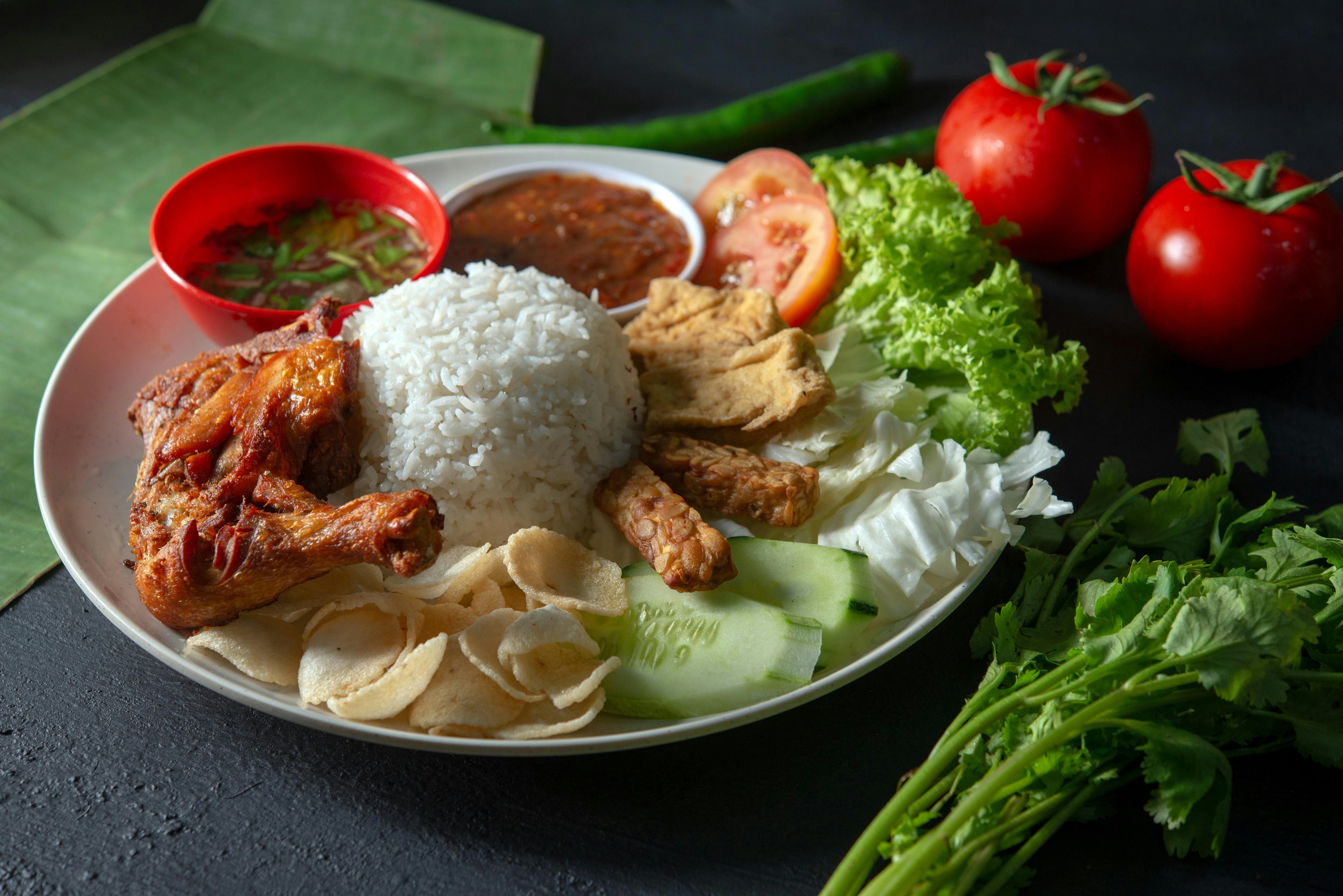 Nasi Lemak served on a banana leaf with sambal, egg, and anchovies.