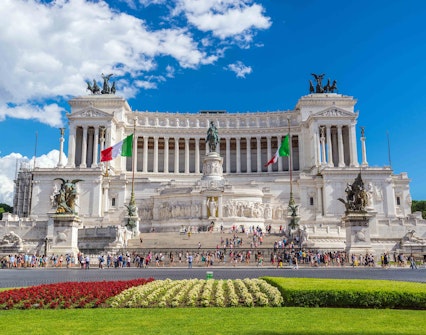 Piazza Venezia in Rome with the Altare della Patria monument and Italian flags.
