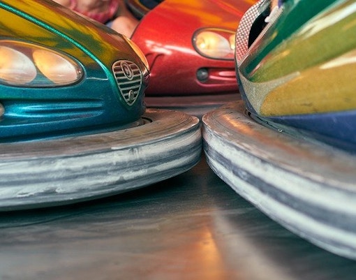 Bumper cars at The Top Penang amusement park, Malaysia, with vibrant lights and riders.