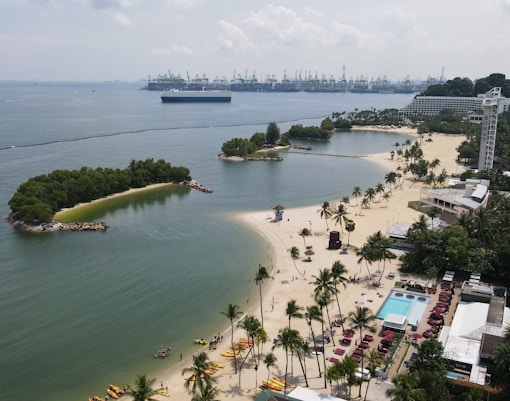 Aerial view of Central Beach Bazaar with sandy shores, palm trees, and nearby islands.