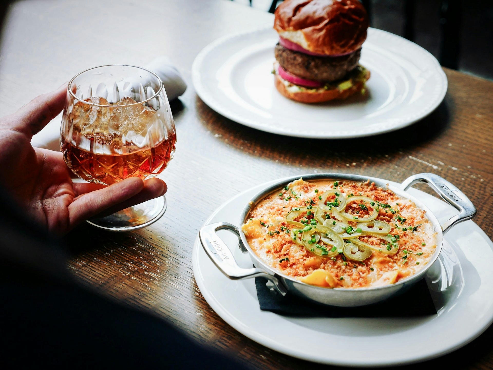 Dining at Aquaventure Water Park with a glass of whiskey, mac and cheese, and a burger.