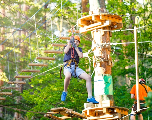 Child ziplining at an adventure park in Rome, Italy.