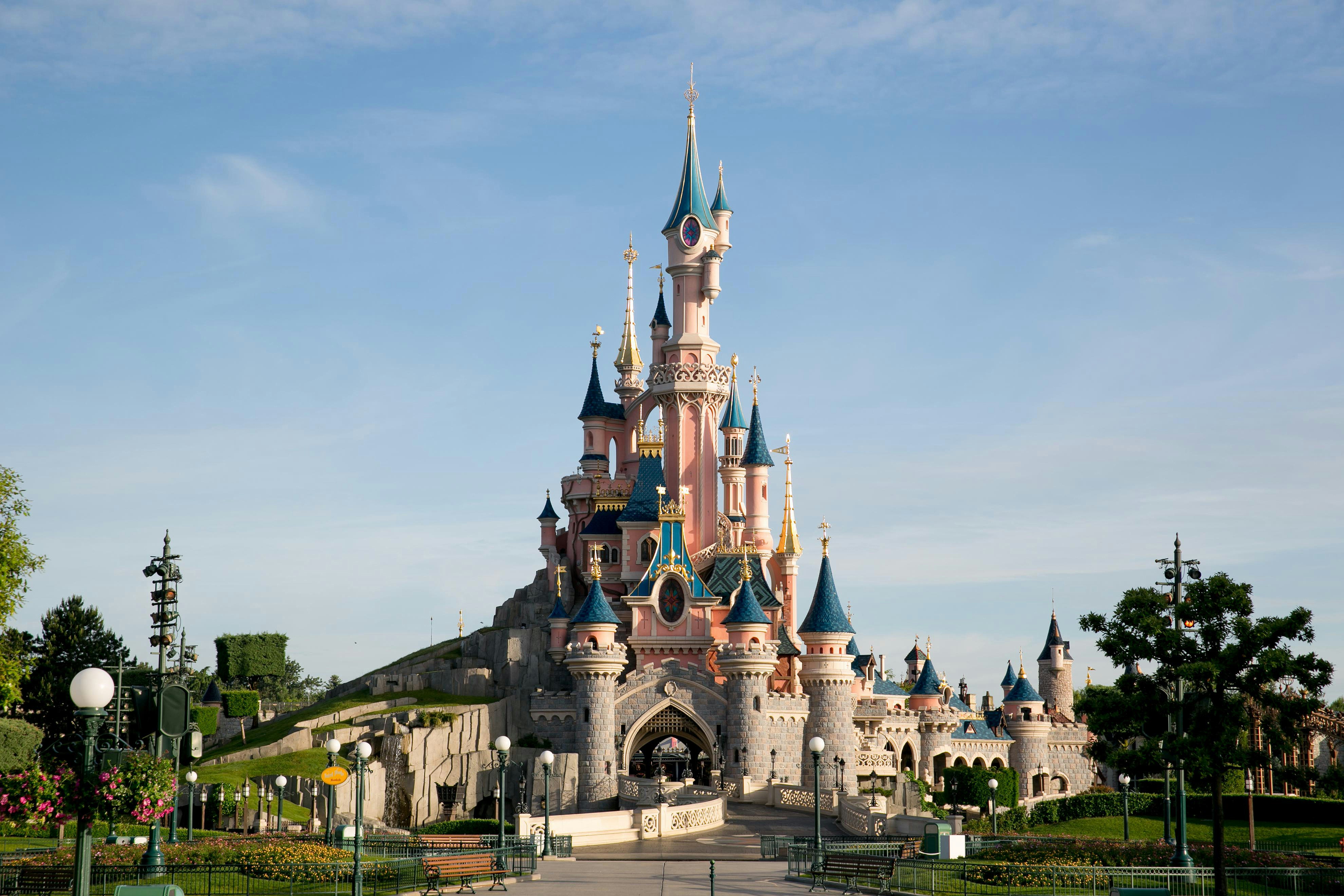 Sleeping Beauty Castle at Disneyland Paris under a clear blue sky.