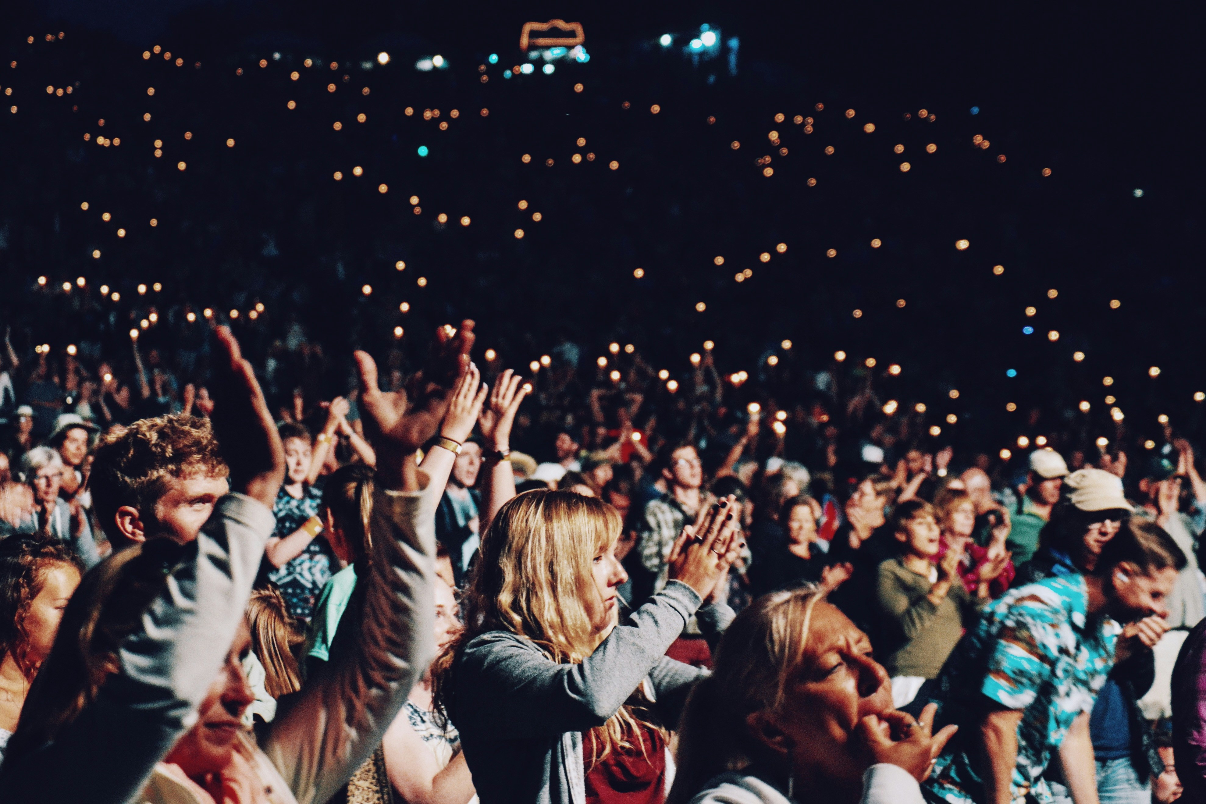 Crowd enjoying a concert at Auditorium Flog with lights in the background.