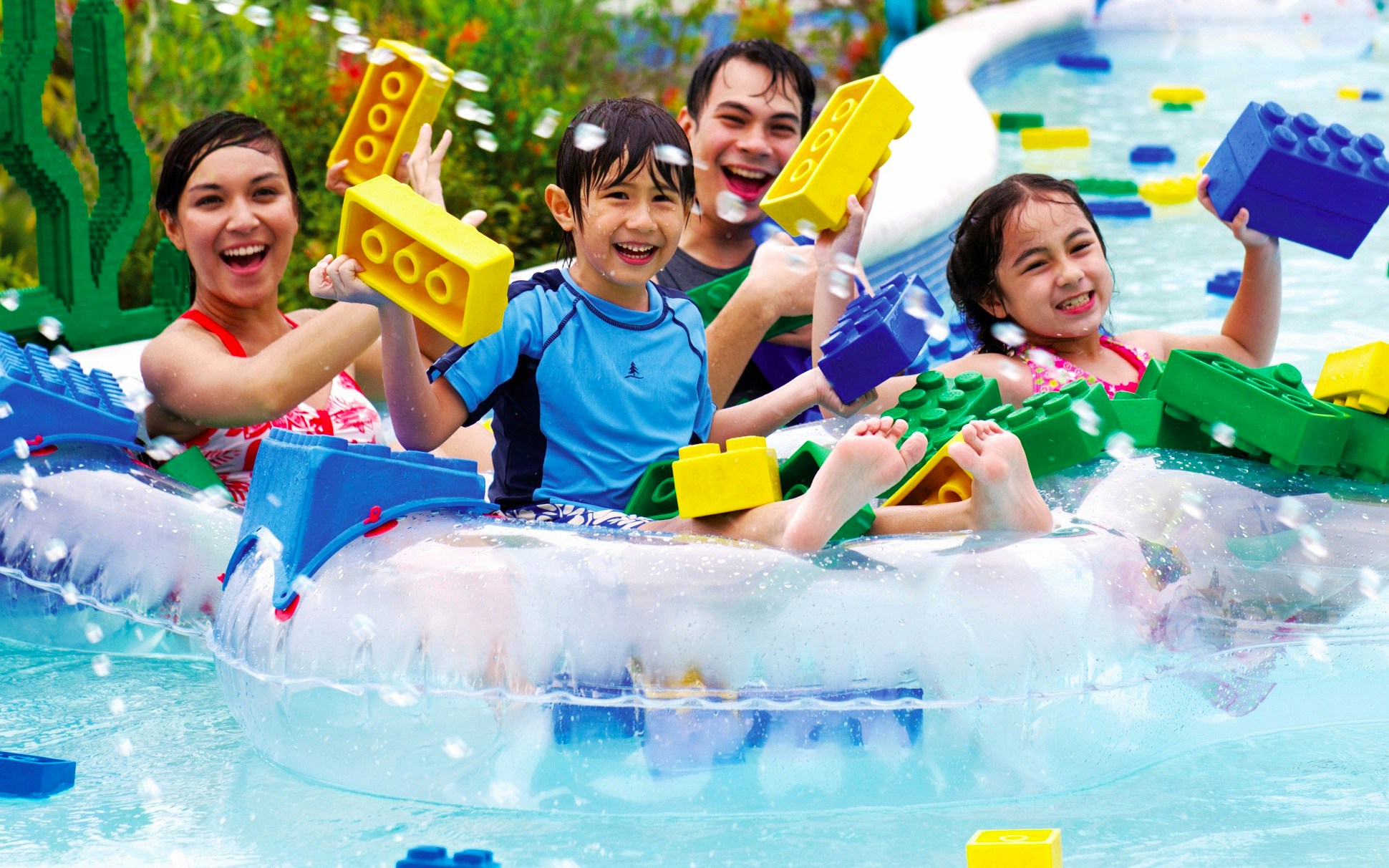 Children enjoying Build-A-Raft River at Dubai LEGOLAND Water Park with large LEGO bricks.