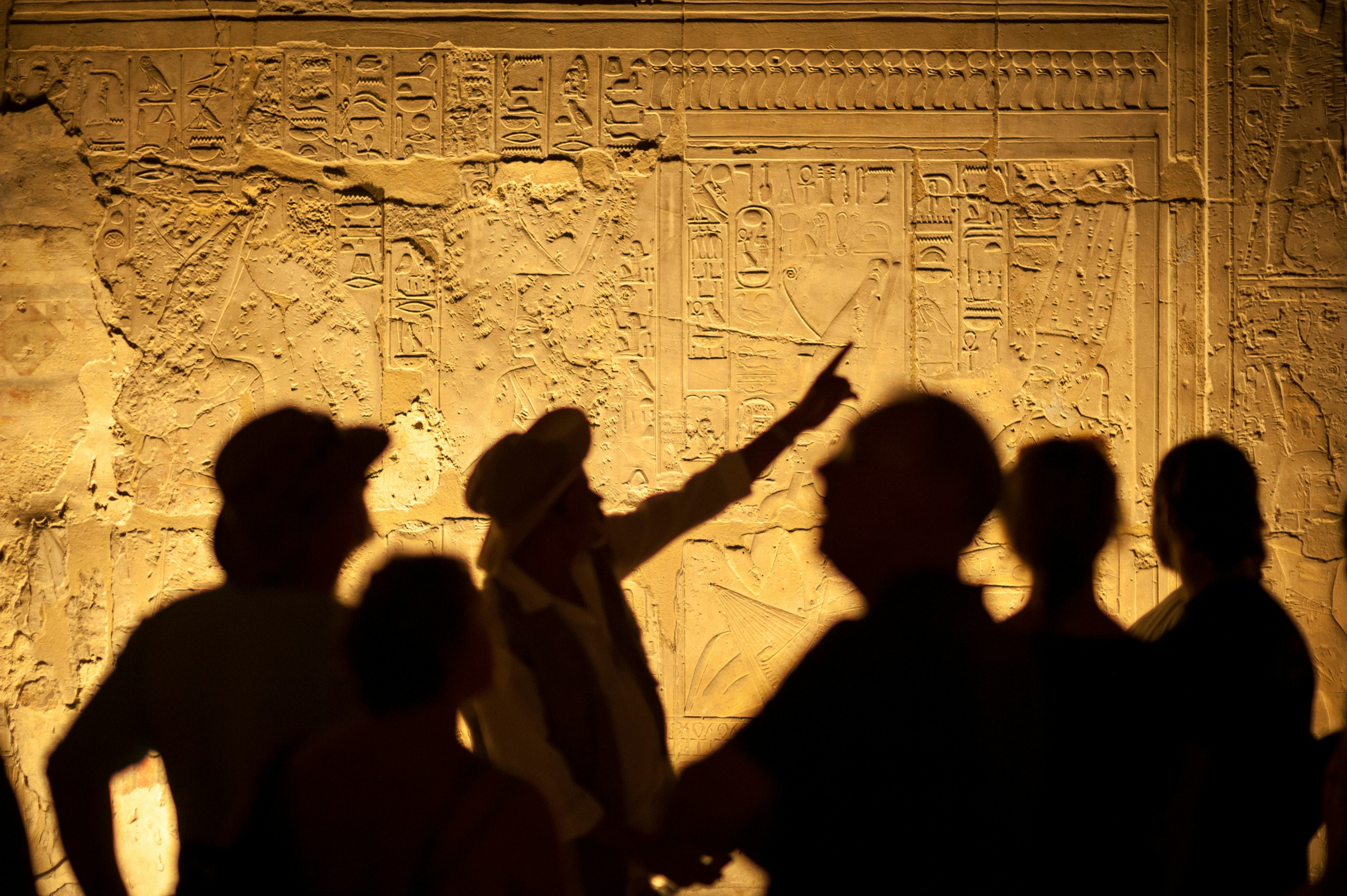 Guide explaining ancient carvings during Naples Underground tour.