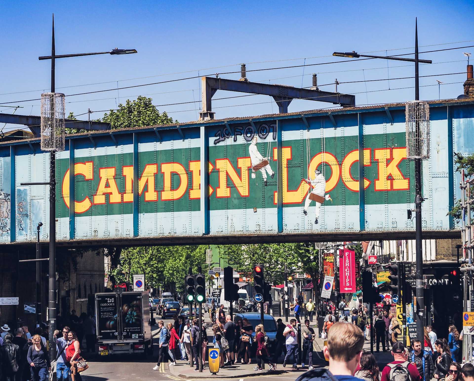 Camden Market stalls with visitors exploring food and crafts in London, UK.