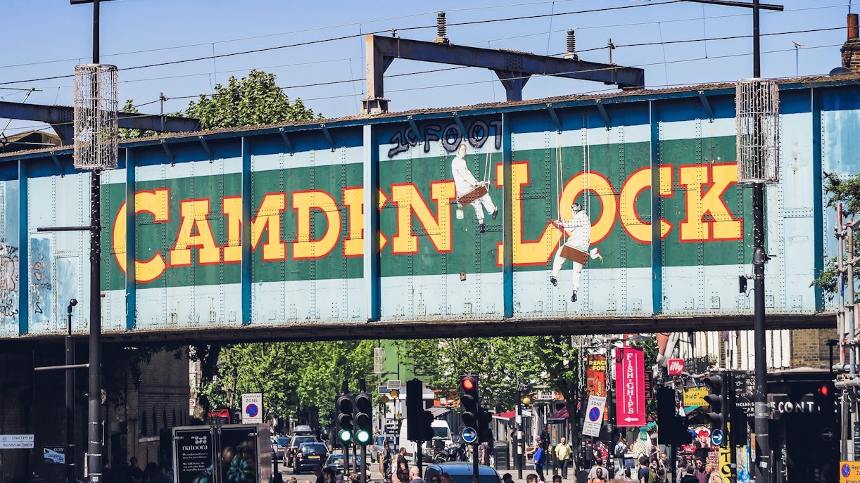 Camden Market stalls with visitors exploring food and crafts in London, UK.