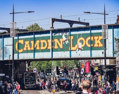 Camden Market stalls with visitors exploring food and crafts in London, UK.