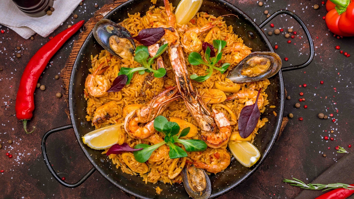 Paella rice dish with seafood and vegetables at a market in Madrid, Spain.