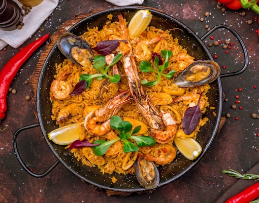 Paella rice dish with seafood and vegetables at a market in Madrid, Spain.