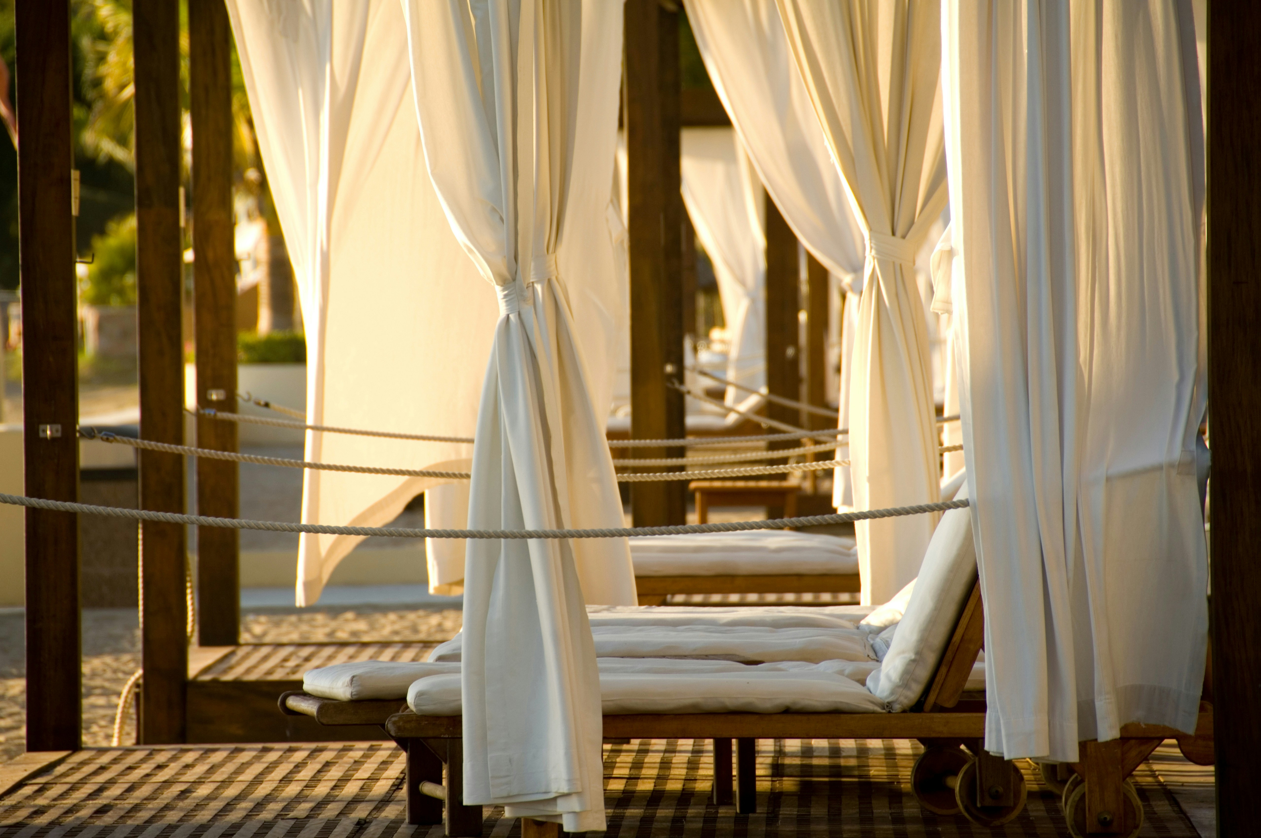 Yas Waterworld Al Waha Cabanas with white curtains and lounge chairs.