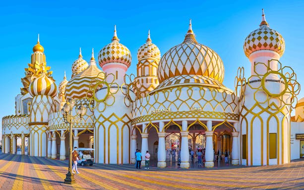 Dubai Global Village entrance with ornate domes and visitors exploring.