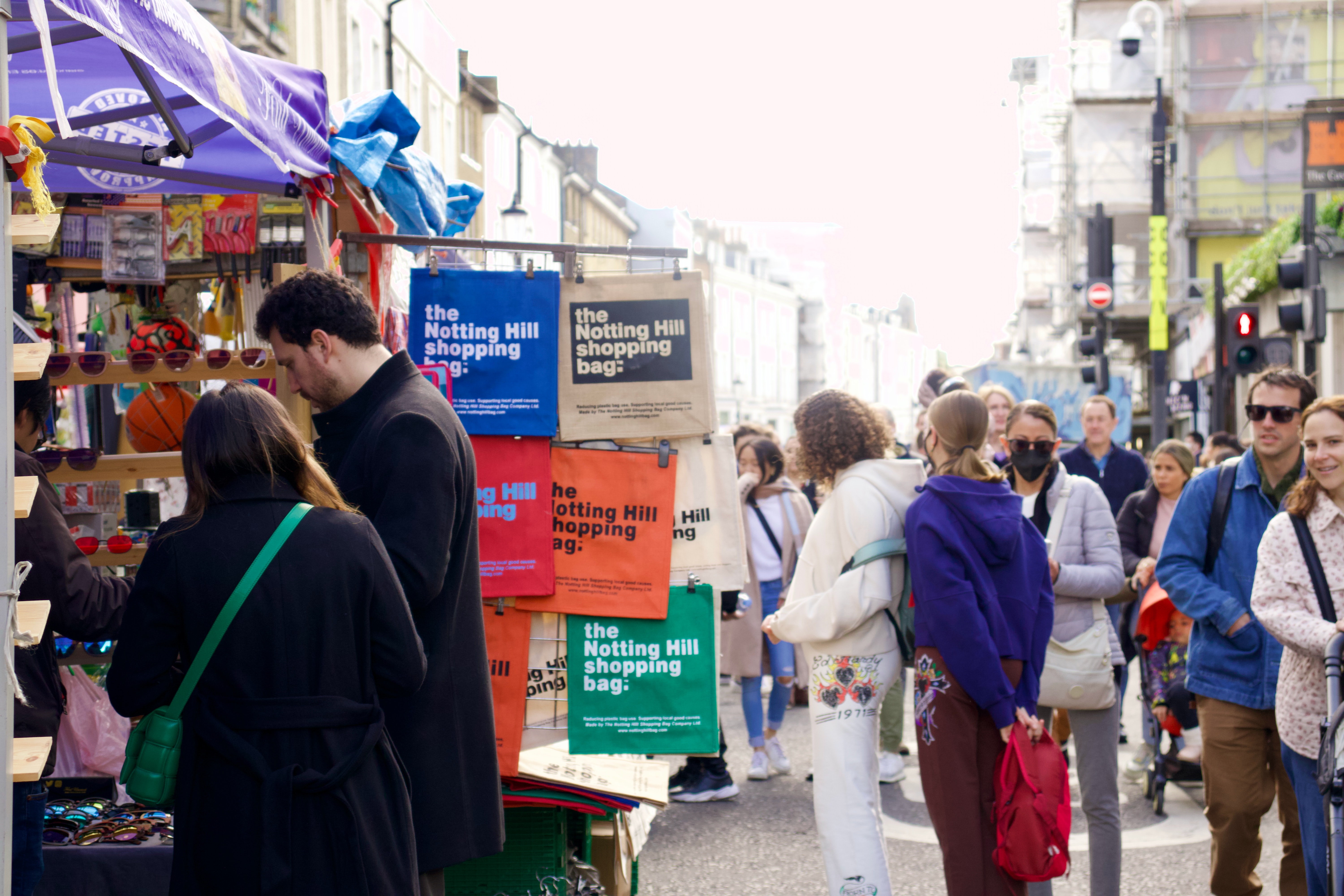 Portobello Road Market shoppers browsing stalls in London.
