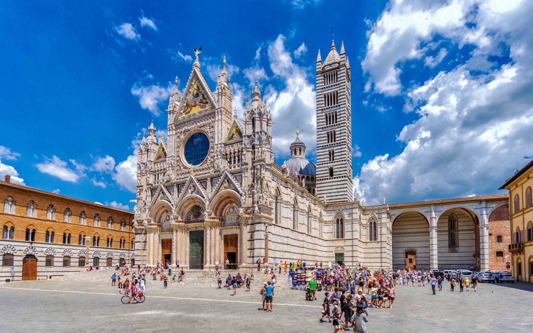 Tourists exploring the exterior of Florence Duomo on a guided tour.