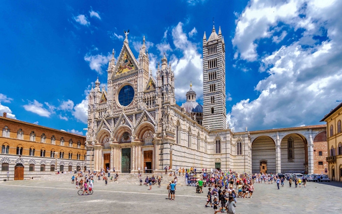Tourists exploring the exterior of Florence Duomo on a guided tour.