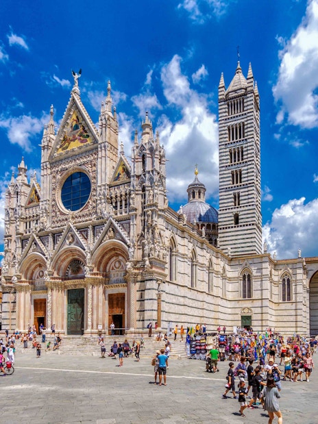 Tourists exploring the exterior of Florence Duomo on a guided tour.