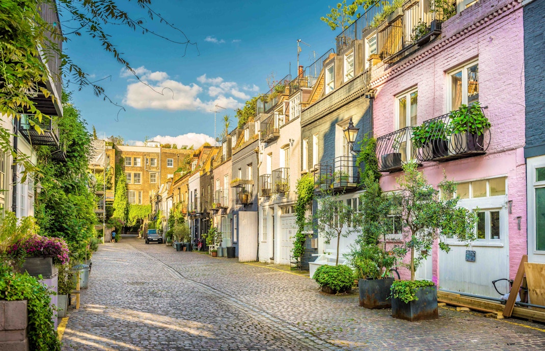 Colorful houses on a cobblestone street in Notting Hill, London, part of the hop-on hop-off tour.
