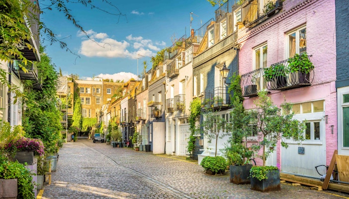 Colorful houses on a cobblestone street in Notting Hill, London, part of the hop-on hop-off tour.