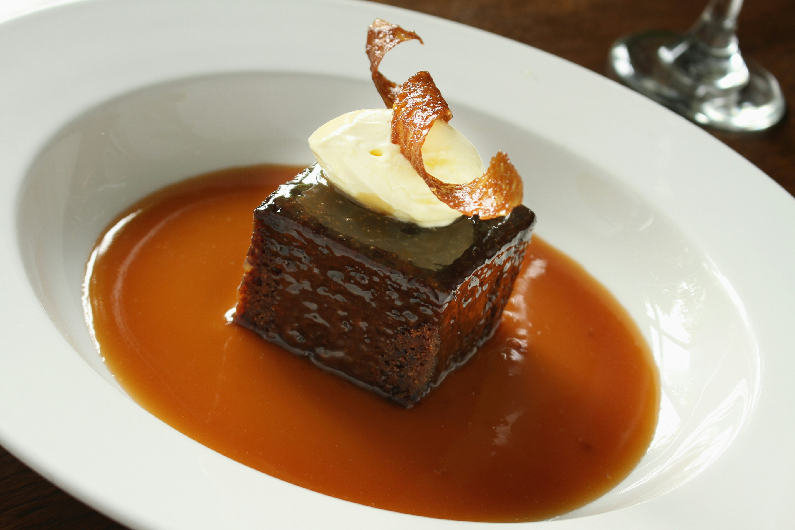 Sticky toffee pudding with caramel sauce and cream in London street food tour.