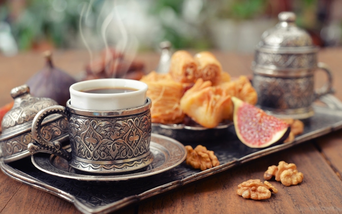 Traditional coffee and pastries served on ornate tray at Yas Waterworld restaurant.