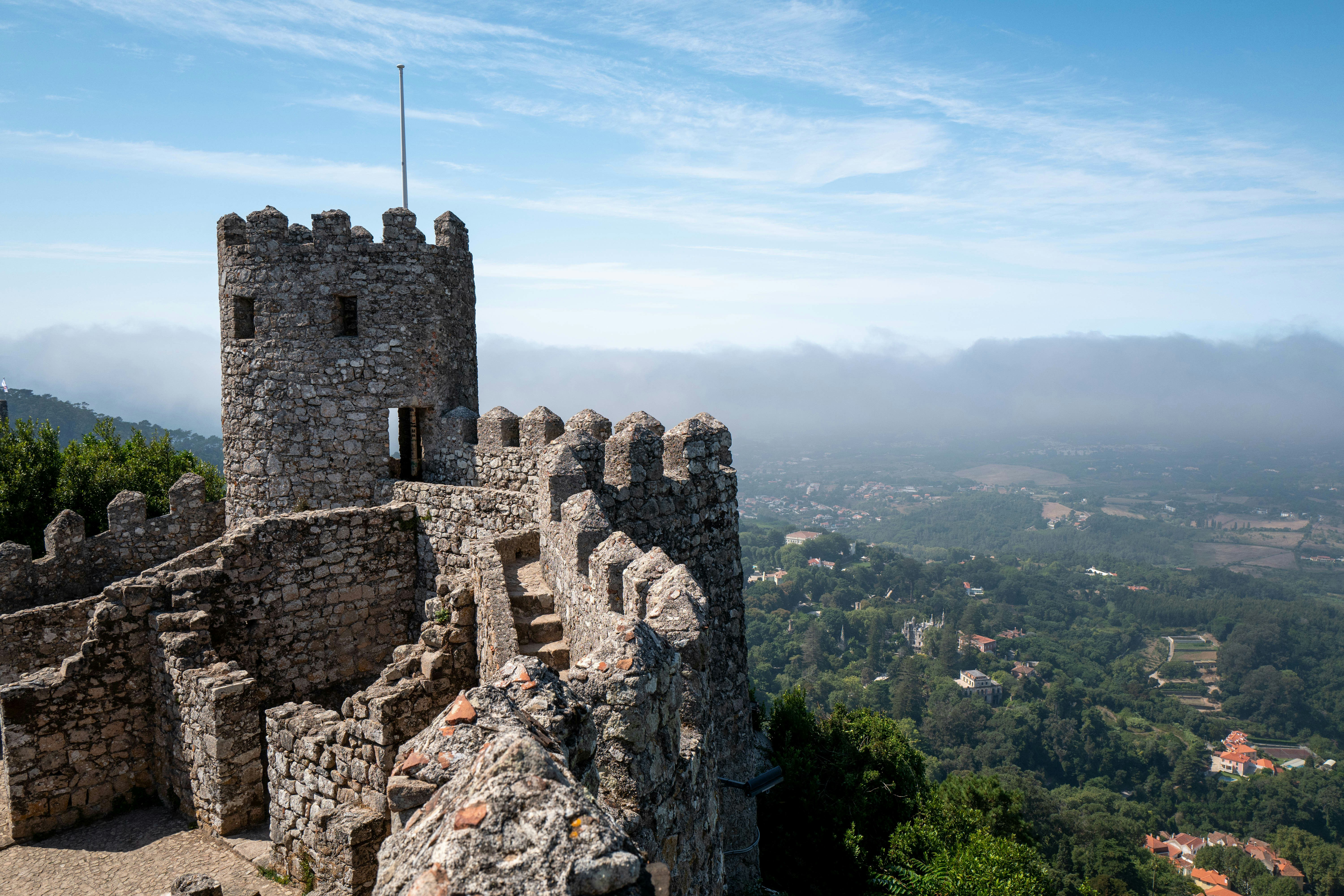 Moorish castle tower overlooking lush Sintra landscape.