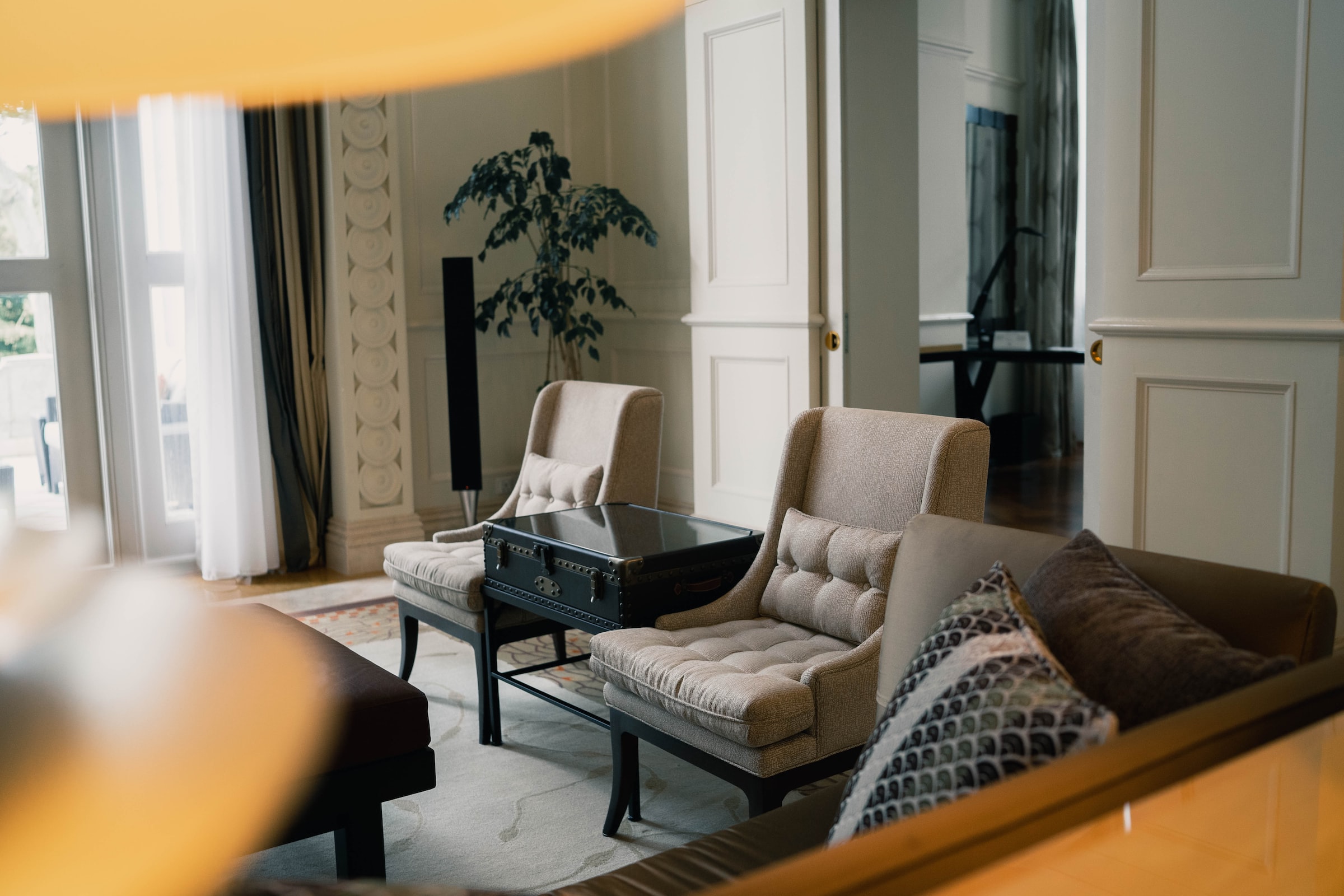 Modern hotel room with large bed, city view, and contemporary furnishings.