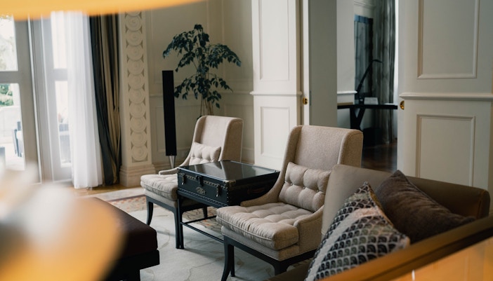 Modern hotel room with large bed, city view, and contemporary furnishings.