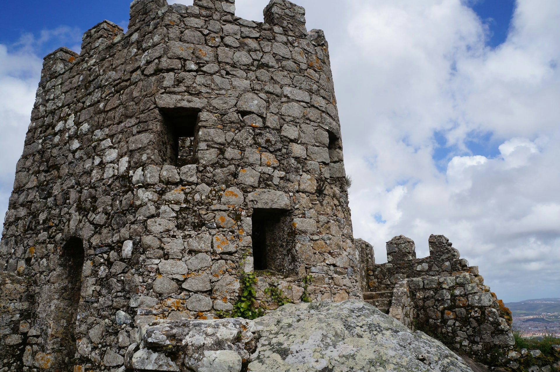 Moorish Castle stone tower in Sintra, Portugal, under a cloudy sky.