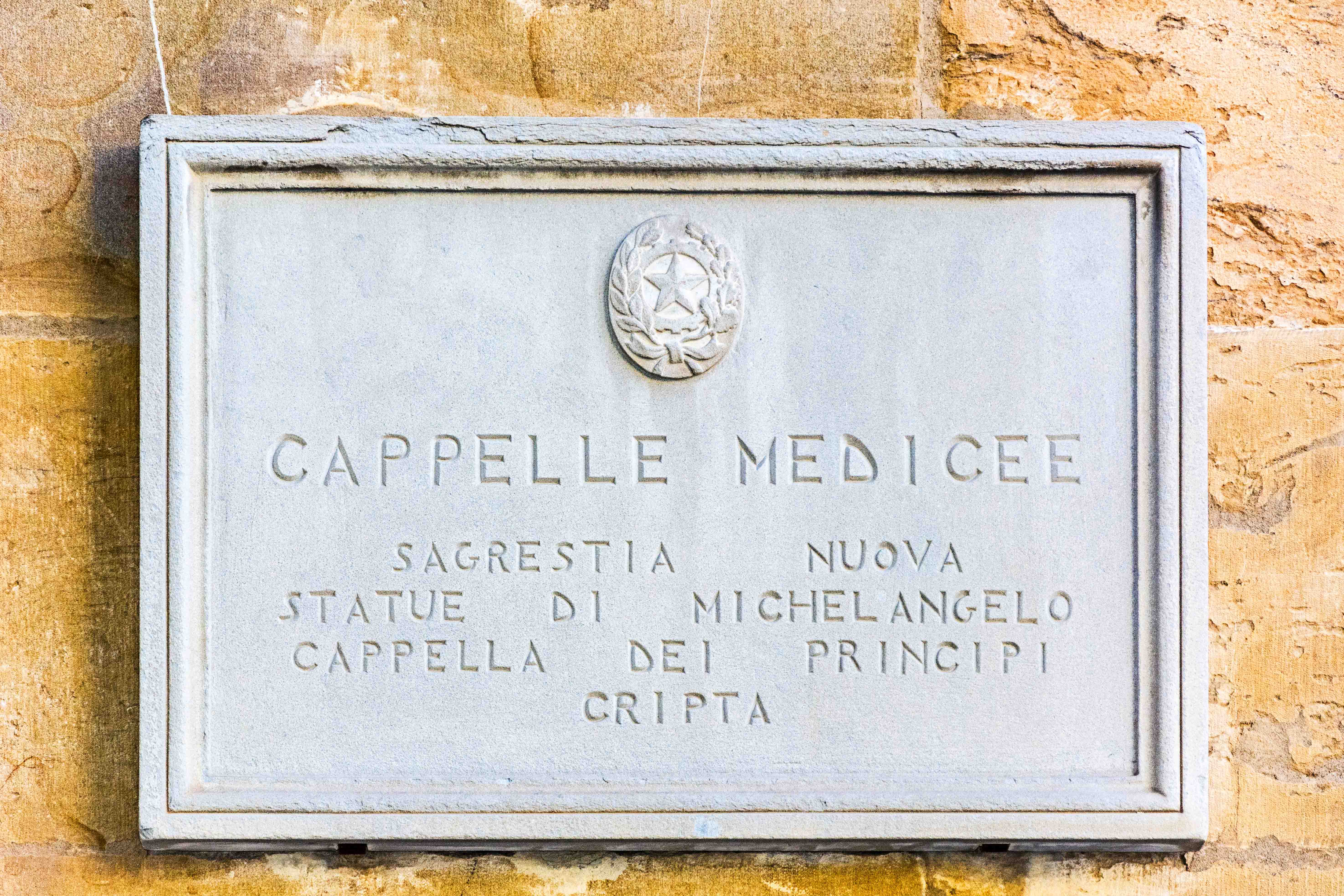 Plaque at Medici Chapels entrance, Florence, featuring Michelangelo's statues.