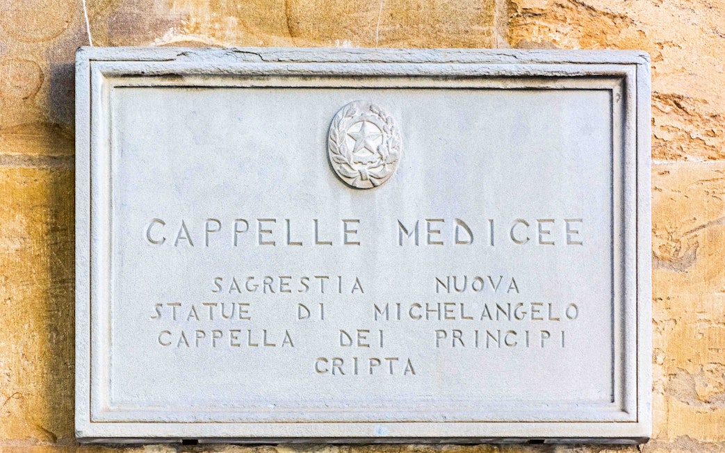 Plaque at Medici Chapels entrance, Florence, featuring Michelangelo's statues.