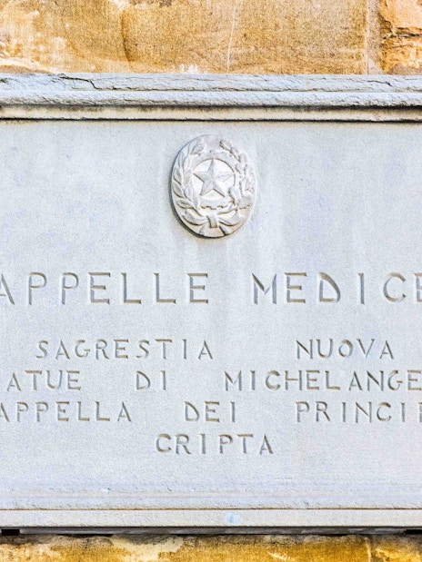 Plaque at Medici Chapels entrance, Florence, featuring Michelangelo's statues.