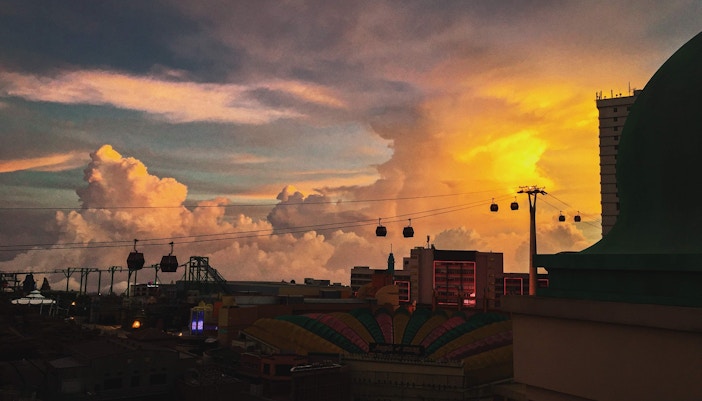 Genting Cable Car gliding over lush hills at sunset, Malaysia.