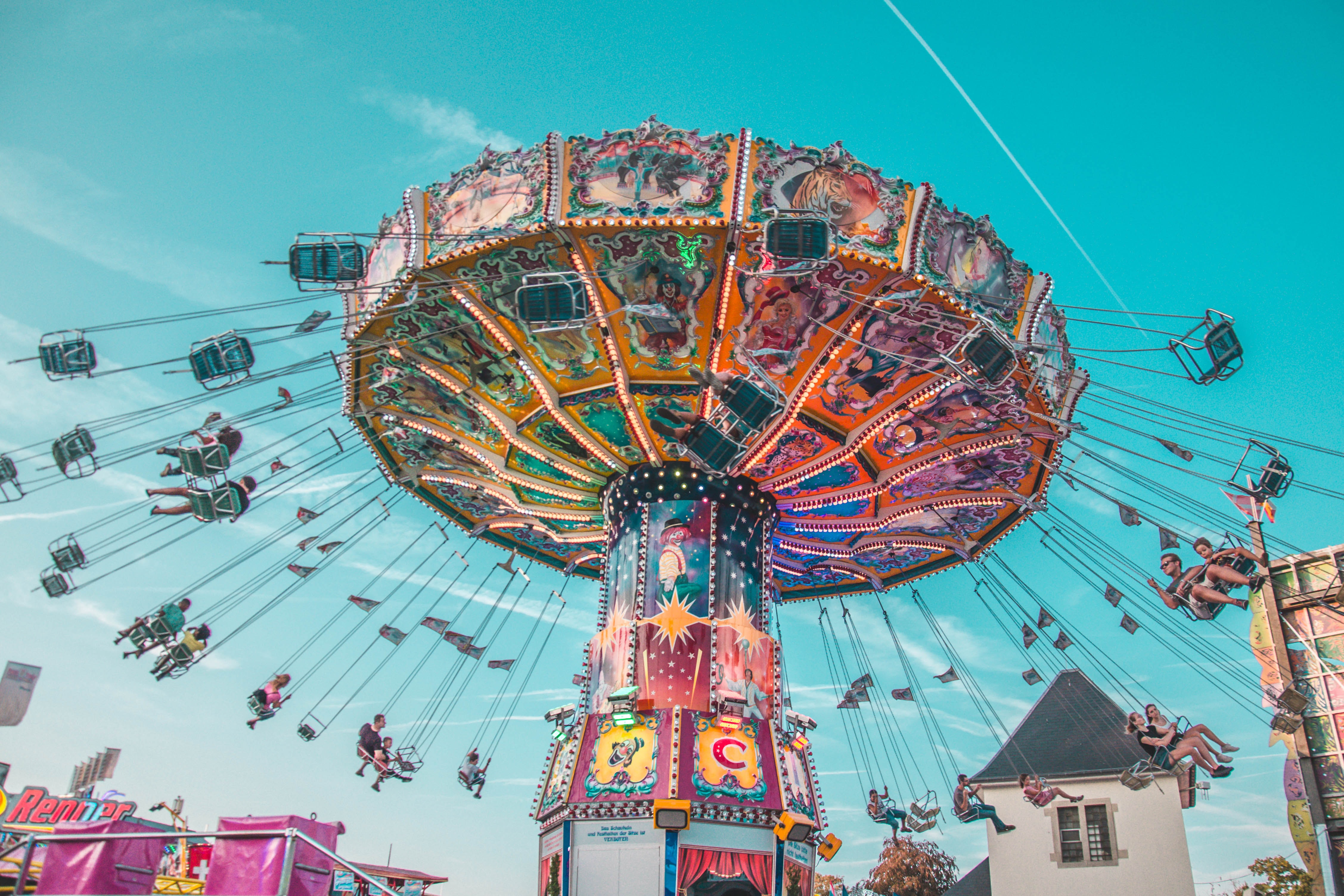 Colorful swing ride at Jardin d’Acclimatation, Paris, with people enjoying the attraction.