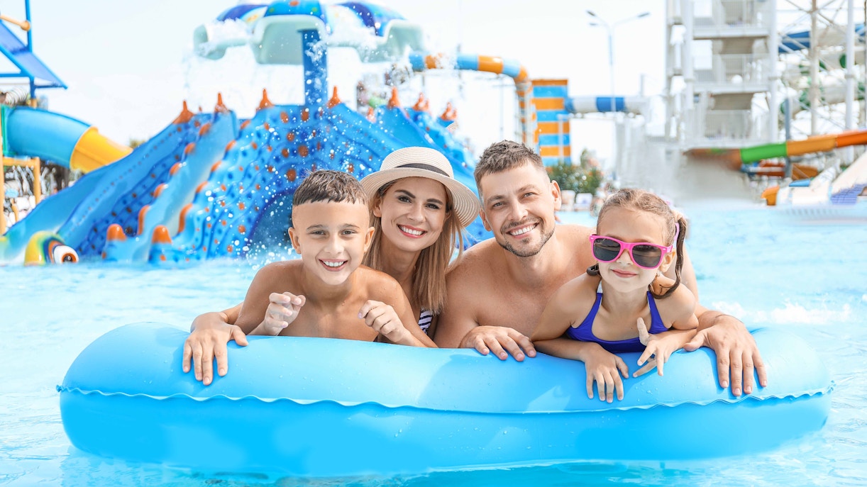 Family enjoying a pool float at Illa Fantasia water park, Barcelona.
