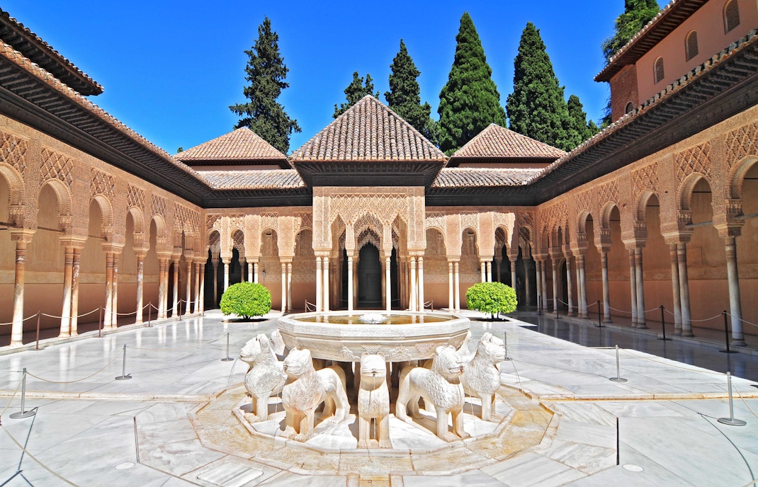 Alhambra palace exterior with intricate arches and columns in Granada, Spain.