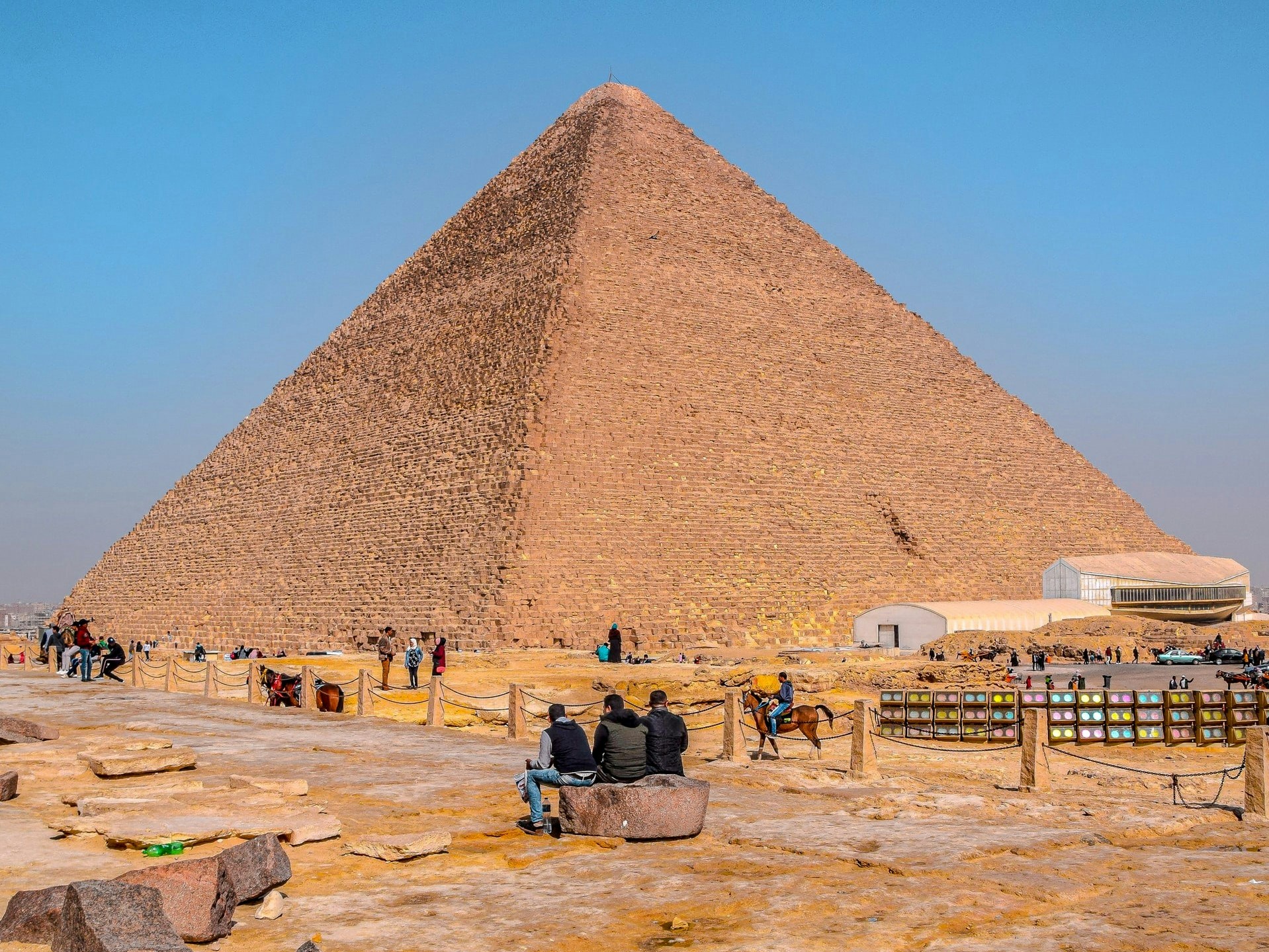 Pyramid of Khufu at Giza with tourists exploring the site.