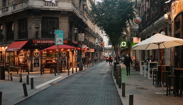 Street view of Barrio de las Letras, Madrid, with cafes and pedestrians.