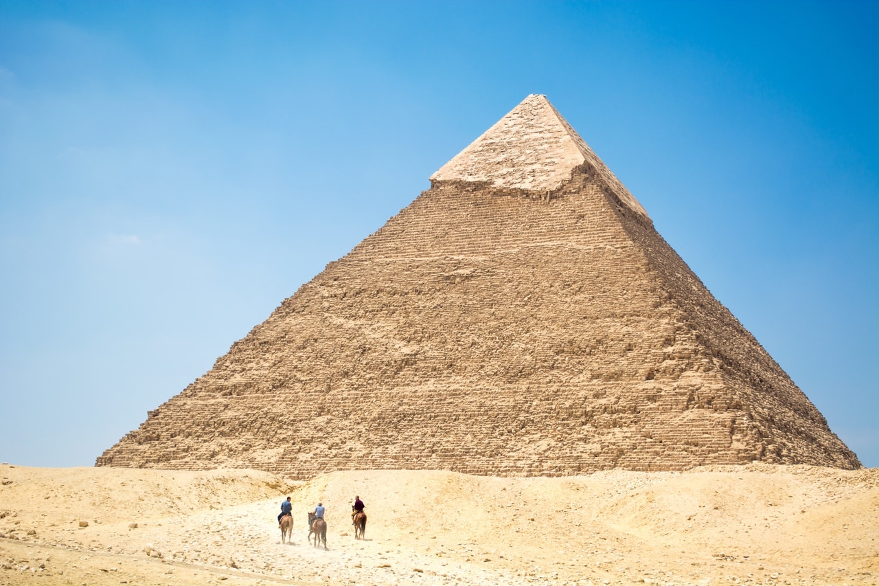 Khafre Pyramid at Giza with three people on camels in the foreground.
