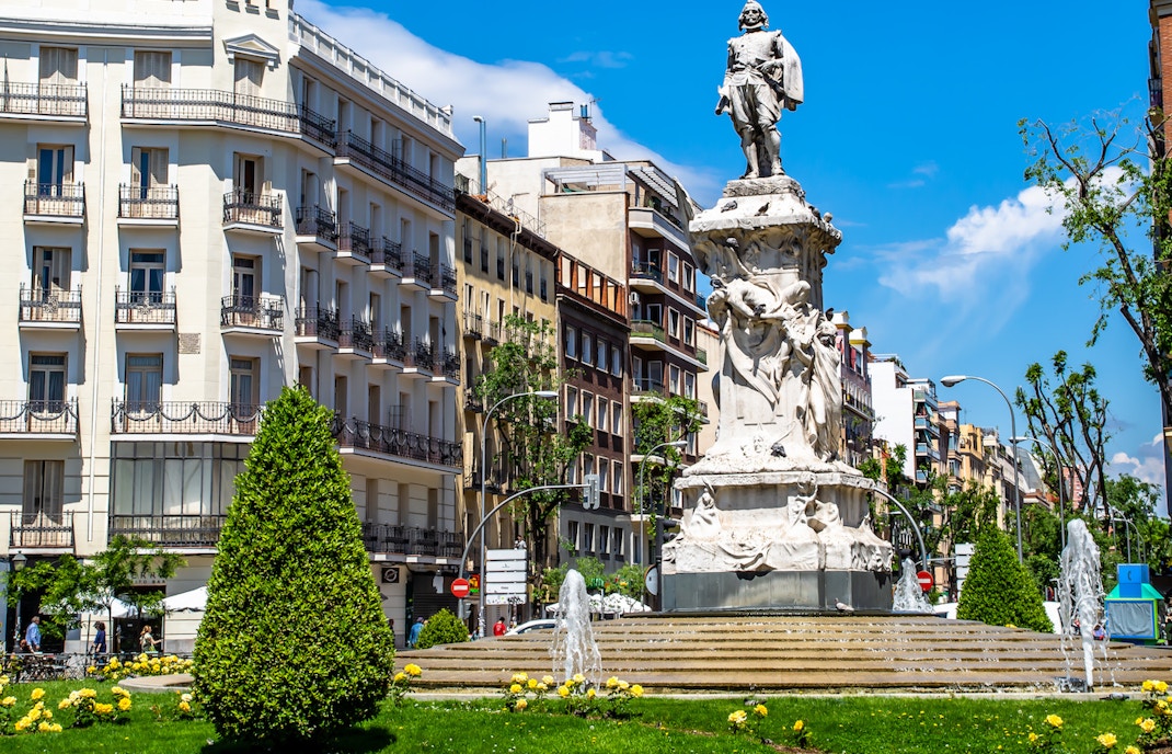 Statue in Chamberi district, Madrid, surrounded by historic buildings and fountains.