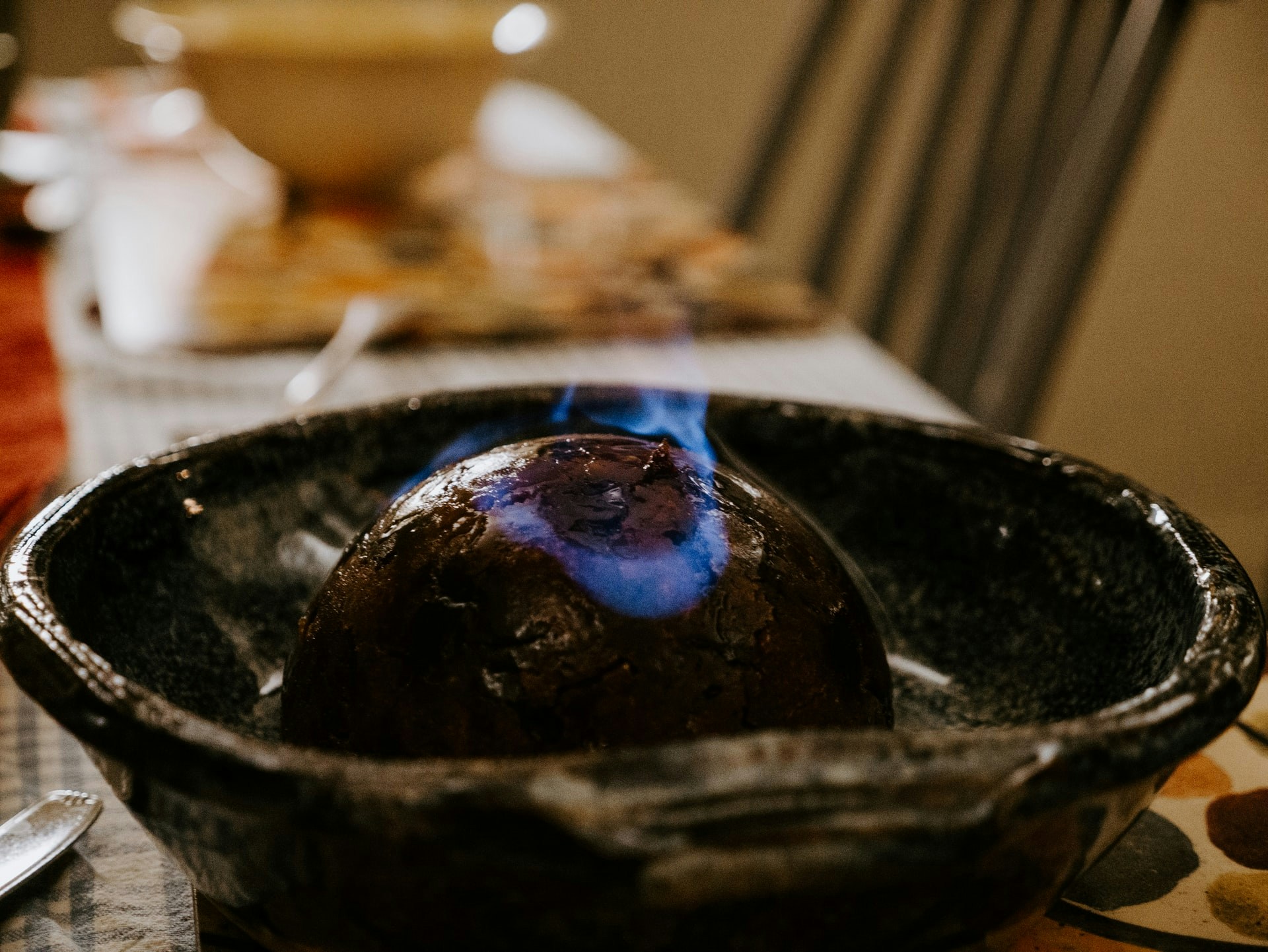 Flaming Christmas pudding on a table in London during December.